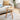 a natural round wood end table in a chic modern living room