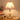 a modern glass table lamp with a chrome base and stained glass shade glowing warmly.