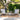 3 Piece Outdoor Furniture Set Image. 3 Piece Patio Set with Grey Adirondack-Inspired Cushioned Chairs and Slatted Top Side Table in an outdoor setting.