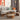 Wooden round coffee table in a modern living room, showing its elevated table top, and pulled out ottomans