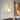 Elegant gold wall light with glass globe illuminated near a wall art