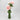 Green sculptural vase with artificial pink peony flowers