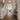Textured acrylic flush mount ceiling light illuminating a classic entryway with wainscoting walls, warm wood flooring, traditional staircase, and antique console table.