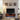 TV stand in a cozy living room with mounted art, soft lighting, and large screen setup.