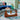 Wood glass coffee table with brown base complementing blue interior