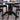 A black round dining table with pedestal base