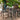 Metal 3 Piece Bistro Set Image. Metal Bistro Set in Floral Design with Lattice-Patterned Seating and Cabriole Legs in an outdoor setting.