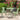 3 Piece Outdoor Furniture Set Image. Green 3 Piece Patio set in Powder Coated Iron with Round Side Table in an outdoor setting.
