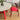 a wood dining table with a round tables top and a red base