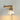 A turned on plug in Wall Lamp with Retractable Arm and ceramic lamp shade in Natural and White