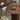 An Up-close image of the Round Pedestal Dining Table in rich walnut color, showcasing the fine groovy design on its pedestal and its smooth table top for serving