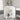 White freestanding cabinet with closed doors, floral arrangement and candle on top.