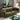 Green sofa in a living room with a coffee table and decorative items.