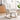Beige glider rocking chair staged in a bright living room with floor lamp and decor