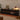 Black LED TV stand at night with amber mood lighting under fluted drawers.