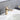 brushed gold bathroom faucet installed on white sink with running water