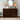 Wooden dresser with decorative items including a lamp, mirror, and flowers in a room.