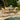 Wooden outdoor dining set with chairs and table by a poolside