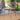 Charmydecor acacia wood square outdoor dining table styled with flower vase on covered patio