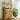 Wooden laundry basket with clothes and a plant in a bright room
