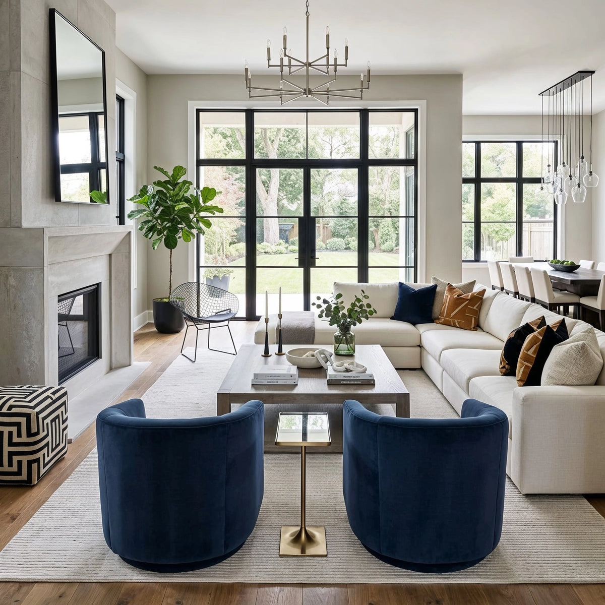 Beige living room with a cream sectional, two curved deep blue velvet accent chairs, a pale rug, gray coffee table, and black-framed windows, by CharmyDecor