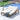 Wooden lounge chair with white cushion by a poolside