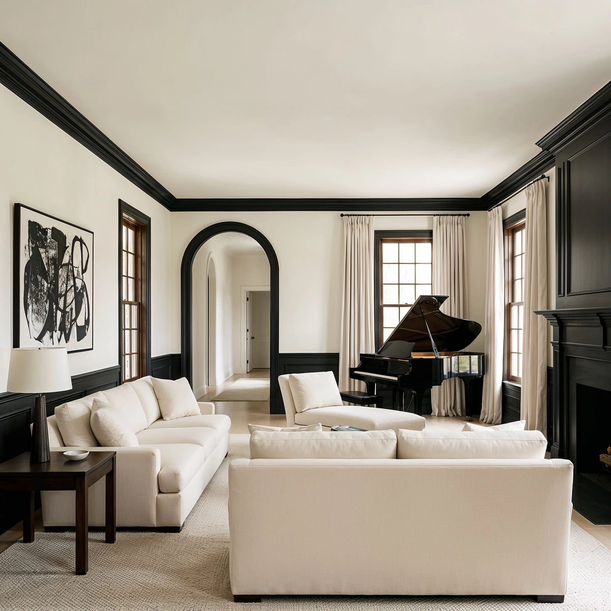 Black living room ideas with black crown molding, paneled lower walls, black arched doorway, fireplace, grand piano, cream sofas, abstract artwork, and neutral decor.