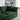 Green sofa in a living room with decorative items on a shelf.