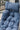 Blue cushioned chair with leaf patterns on a blurred outdoor background