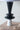 Black and white tiered candle holder on a wooden surface with a neutral background
