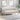 Beige tufted sofa in a living room setting with abstract art and a plant.