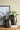 Decorative vases with a floral arrangement on a table against a beige wall.