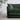 Green sofa in a room with a plant and light-colored floor.