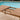 Charmydecor expandable acacia wood patio dining table showing extension mechanism beside pool