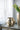 Two metallic vases on a reflective surface with a light curtain background