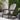 charmydecor gray folding acacia wood Adirondack chair displayed beside greenery on an outdoor patio
