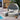 Outdoor patio set with canopy and ottomans by a poolside.