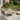 Charmydecor green PE rattan patio conversation set with loveseat, two club chairs, and round acacia wood table on backyard patio