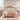 Pink quilted comforter set on a bed in a bedroom with side tables and decor.