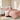 Bedroom with pink quilted bedding and floral wallpaper