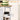 White kitchen cart with removable tray, green bowls, and jars on a wooden surface.