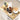 Wooden table with kitchen items including jars, a coffee maker, and utensils on a textured floor.