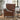 Brown leather recliner chair in a living room setting with a plant and side table.