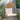 Charmydecor Malia hanging chair with brown PE rattan basket frame and beige cushions on covered patio