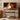 TV screen displaying a romantic scene with a couple, placed on a stand in a room with decor elements.