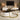 Modern living room with round coffee table, decorative items, and a television.