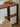 Wooden sideboard with glass panels and decorative items on a wooden floor.