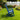 Charmydecor navy blue patio rocking chair shown from the side in a landscaped backyard garden