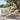 Charmydecor outdoor 5-piece dining set with teak wood table and wicker chairs with white cushions beside a pool