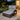 Outdoor patio chair with cushions on a stone patio, evening setting.
